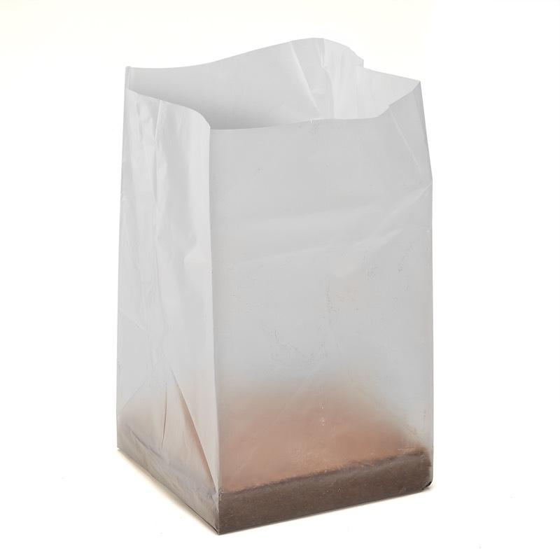 Clear plastic bag with coco coir inside on a white background